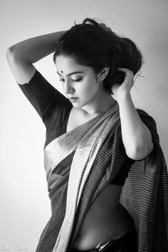 black and white photograph of a woman wearing a sari with her hands on her head