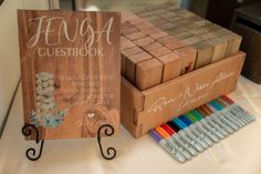 a wooden guest book sitting on top of a table next to crayons and markers