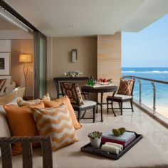 a living room filled with furniture next to the ocean