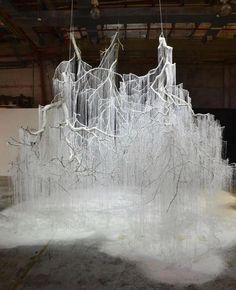 an art installation made out of ice and icicles in a large room with exposed ceilings