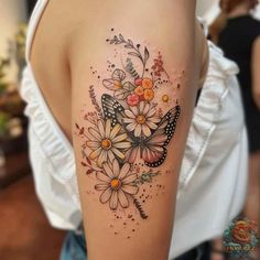 a woman with a butterfly and flowers tattoo on her arm