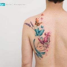 the back of a woman's shoulder with flowers and butterflies on her left side