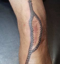 a man's leg with a tattoo on it that is shaped like a snake