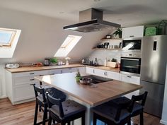 a kitchen with an island, stove and refrigerator