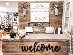 the front desk of a store with wooden walls and welcome signs on it's sides