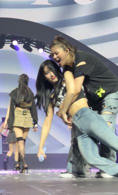 two young women are dancing on stage together