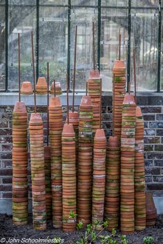 stacks of clay pots sitting in front of a window