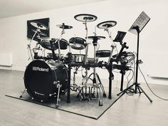 a black and white photo of a drum set on a rug in an empty room