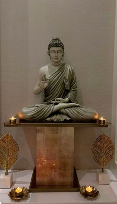 a buddha statue sitting on top of a wooden table