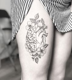 a black and white photo of a woman's thigh with flowers on it,