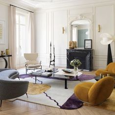 a living room filled with furniture and a fire place next to a mirror on the wall