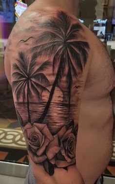 a man's arm with roses and palm trees on it