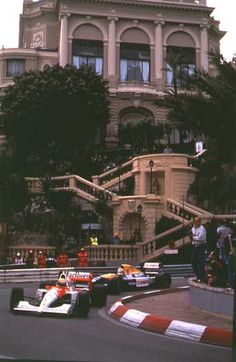 the cars are racing down the street in front of an old building