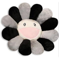 a black, white and grey flower shaped plush toy with pink tongue on it's face