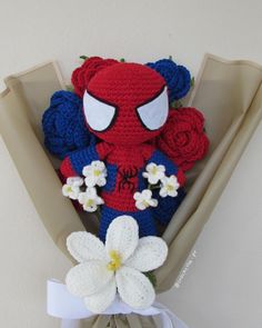 a crocheted spiderman stuffed animal with flowers