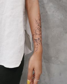 a woman's arm with a flower tattoo on the left side of her arm