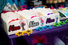 several boxes with name tags on them are sitting on a purple countertop in front of other items