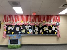 an empty classroom with red and white drapes on the wall, decorated with teddy bears