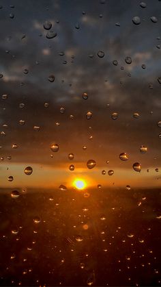 the sun is shining through raindrops on a window