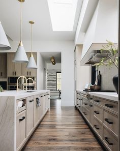 a large kitchen with wooden floors and white walls, along with an open floor plan