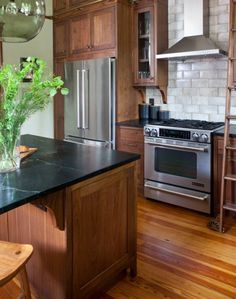 a kitchen with wooden cabinets and an island in front of a stove top oven next to a ladder