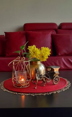 a table topped with a vase filled with yellow flowers and a horse drawn carriage next to it