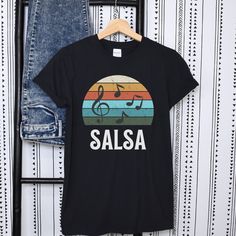 SALSA tshirt,salsa lover shirt,Salsa music shirt,Salsa dance t-shirt,Latin music shirt,Salsa dance party shirt,Salsa rhythm t-shirt,gift. You've now found the staple t-shirt of your wardrobe. It's made of 100% ring-spun cotton and is soft and comfy. The double stitching on the neckline and sleeves add more durability to what is sure to be a favorite!   * 100% ring-spun cotton * Sport Grey is 90% ring-spun cotton, 10% polyester * Dark Heather is 65% polyester, 35% cotton * 4.5 oz/yd² (153 g/m²) * Shoulder-to-shoulder taping * Quarter-turned to avoid crease down the center Fitted Music-themed T-shirt For Summer, Summer Music-themed Fitted T-shirt, Fitted Music-themed Summer T-shirt, Graphic Print Short Sleeve T-shirt For Fiesta, Casual Short Sleeve Tops For Fiesta, Latin Party, Dance T Shirt, Salsa Music, Salsa Dance