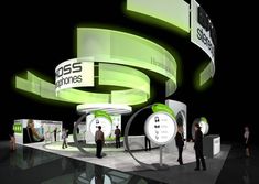 people are standing in front of an exhibition stand with green lights on the walls and signs above them