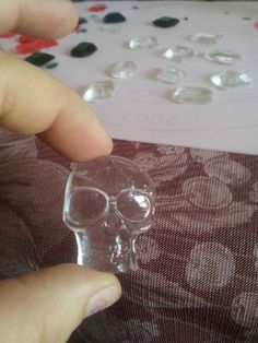 a person is holding a crystal skull in front of a sheet of paper with buttons on it