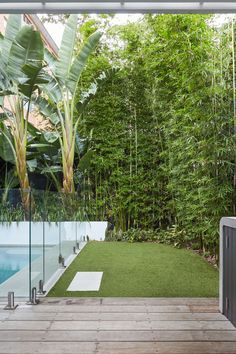 an outdoor living area with grass and plants on the deck, next to a swimming pool