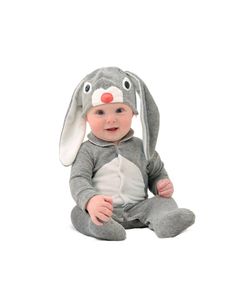 a baby sitting on the ground wearing a bunny costume