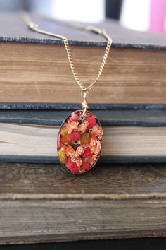 This oval orgonite pendant is made up of 2 layers. The top layer is rose gold flakes, copper slivers, bamboo coral, tigers eye, and red agate. The bottom layer is a mix of metal shavings, quartz, pyrite, and tourmaline. It hangs from an 18 inch chain. Orgonite is a mixture of resin, crystals, and metals. Orgonite Pendant, Resin Crystals, Coral Rose, Bamboo Coral, Gold Flakes, Red Agate, Tigers Eye, Crystal Necklace, Or Rose