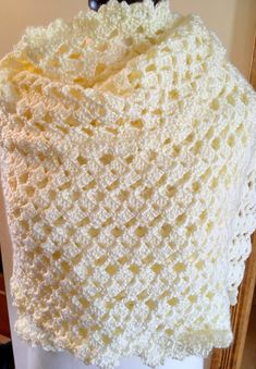 a white crocheted shawl on top of a mannequin