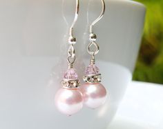 Pink pearl earrings are handmade with Swarovski pearls, rhinestone crowns and blush pink crystals. Set on sterling silver wire and earring french wire earring closures (hooks). A lovely bridesmaid gift, these pink earrings are a short dangle style which will complement any wedding ensemble. Perfect for spring weddings and feminine sundresses. Earring Details: - Earring total length is 1.25 inches (3.17 cm) including the earring closures - Pearls are 8 mm in diameter - Choose sterling silver or 1 Pink Pearl Jewelry, Pink Pearl Bracelet, Pink Pearl Earrings, Bridesmaid Pearl Earrings, Pink Crystal Earrings, Pink Pearl Necklace, Bridesmaid Pearls, Pink Swarovski, Pink Jewelry