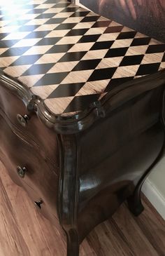 a checkered table top with black and white tiles on the bottom, next to a chair