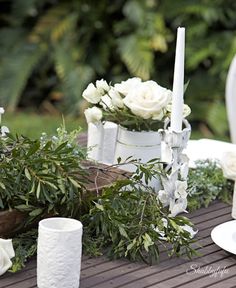 a table topped with white flowers and candles