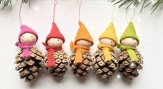 three little gnomes are hanging from pine cones