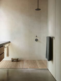 a bathroom with a wooden floor and white walls