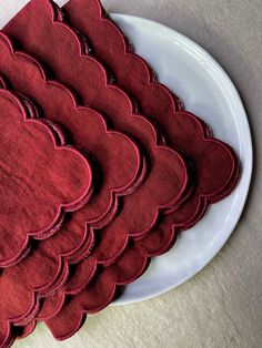 a white plate topped with lots of red heart shaped napkins on top of a table