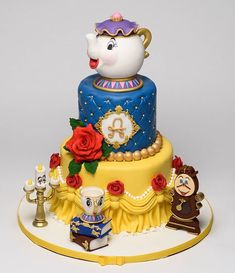 there is a cake decorated with beauty and the beast characters