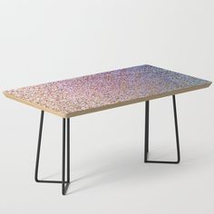 a pink table with black metal legs on a white background, it looks like an abstract piece of art