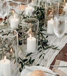 the table is set with candles, plates and silverware