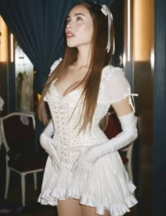 a woman in a white dress is posing for the camera