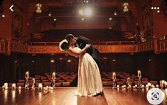 a man and woman are kissing on the dance floor in front of rows of candles