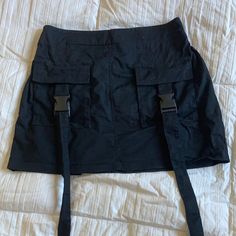 Super Cute Black Mini Cargo Skirt With A Stretchy Back Deep Pocket And Cool Buckle Design. Used Ones But Basically Like Brand New 14” Or So Waist When Relaxed But Has Stretchy Back And Can Stretch Up To 16” Or So High Waist Black Cargo Skirt With Belt Loops, Black High-waist Cargo Skirt With Belt Loops, High-waist Black Cargo Skirt With Belt Loops, Black Cargo Skirt With Pockets For Summer, Black Mini Cargo Skirt With Side Pockets, Fitted Black Cargo Skirt With Pockets, Black Mini Cargo Skirt With Belt Loops, Y2k Black Skort With Pockets, Black Y2k Skort With Pockets