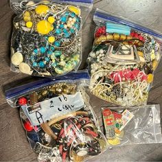 three bags filled with lots of different types of beads and bracelets on top of a wooden table