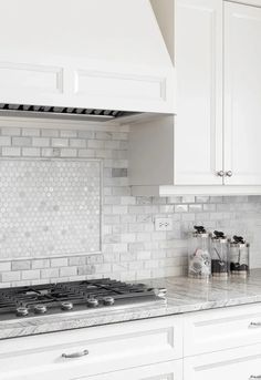 a kitchen with white cabinets and marble counter tops on the backsplash is seen in this image