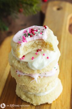 a stack of cookies with frosting and sprinkles