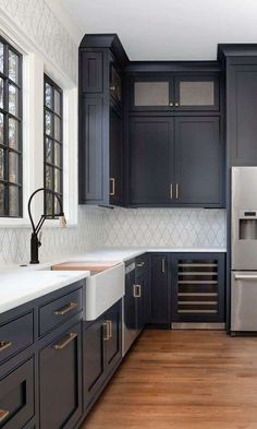 a kitchen with black cabinets and white counter tops