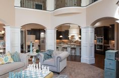 a living room filled with furniture next to a kitchen and an open concept floor plan